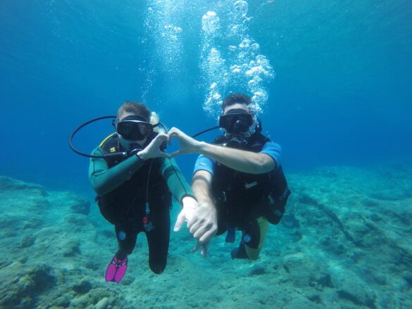 A Sweet Couple Swimming Underwater while Holding Each Others Hand A Sweet Couple Swimming Underwater while Holding Each Others Hand