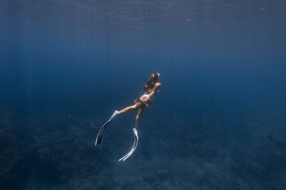 Unrecognizable woman swimming undersea near coral reefs Unrecognizable woman swimming undersea near coral reefs