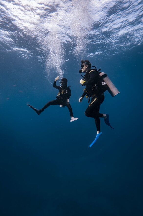 Scuba Divers with Equipment Underwater Scuba Divers with Equipment Underwater
