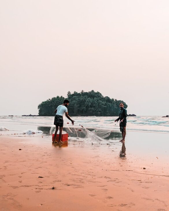 Unrecognizable Indian fishermen catching fish on sea shore Unrecognizable Indian fishermen catching fish on sea shore