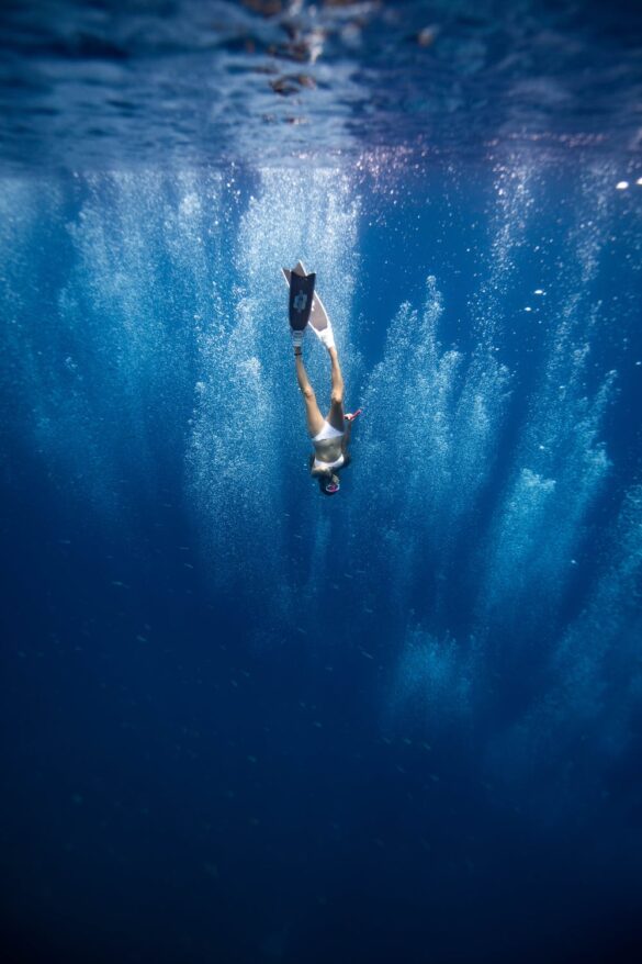 Unrecognizable lady swimming underwater after jumping in ocean Unrecognizable lady swimming underwater after jumping in ocean