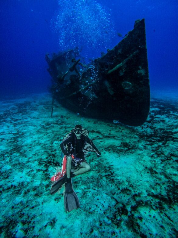 Scuba Diver Posing Near an Old Abandoned Ship Underwater Scuba Diver Posing Near an Old Abandoned Ship Underwater