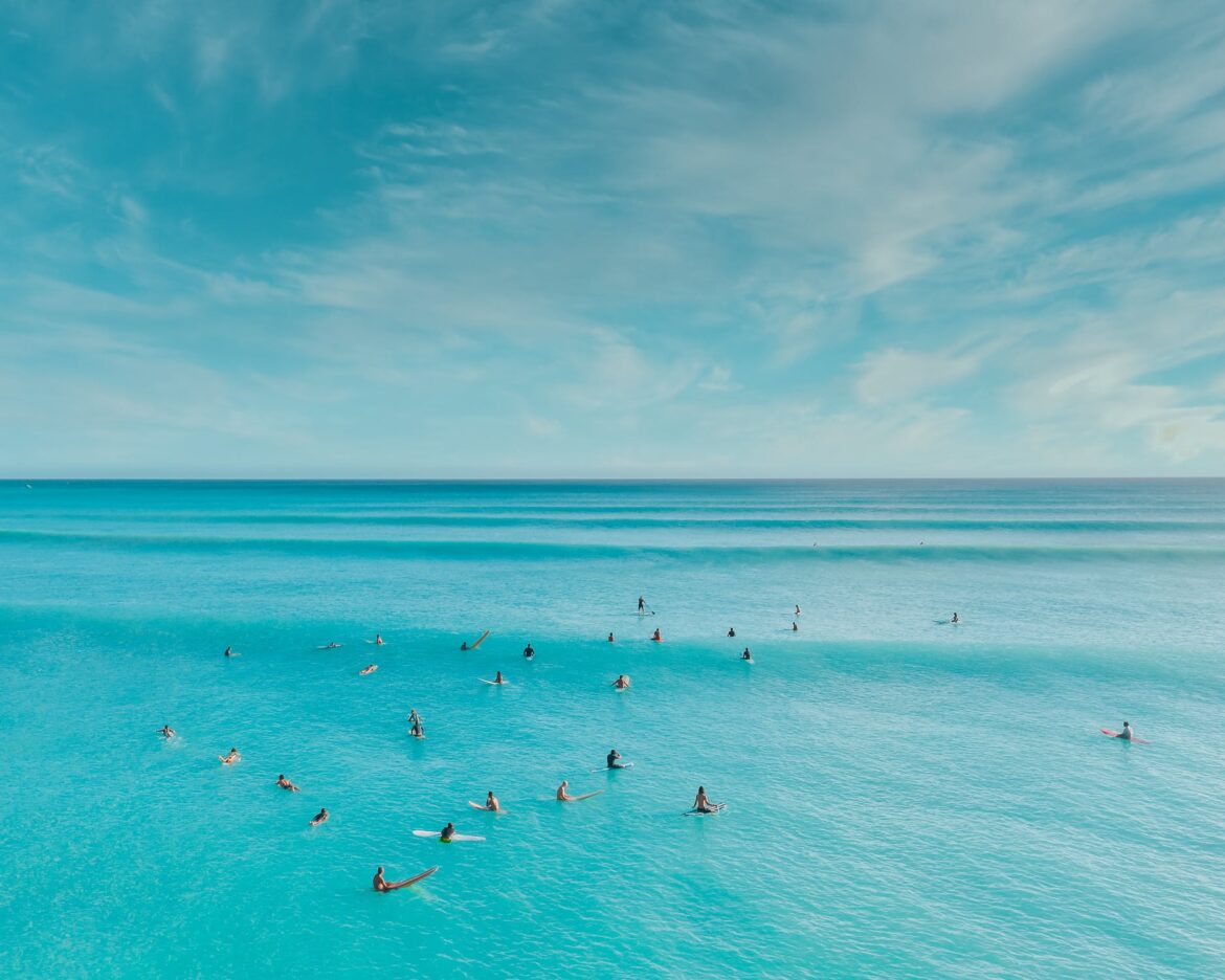 Surfers on Sea Under Blue Sky