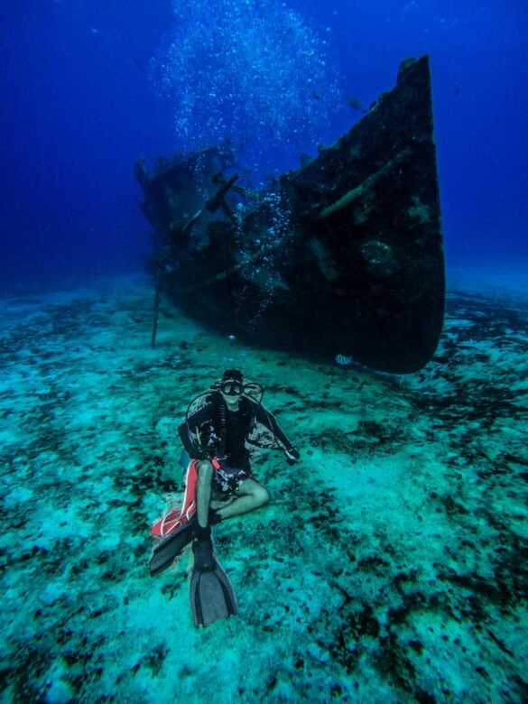 Scuba Diver Posing Near an Old Abandoned Ship Underwater Scuba Diver Posing Near an Old Abandoned Ship Underwater