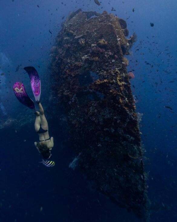 Woman Swimming Underwater Near a Shipwreck Woman Swimming Underwater Near a Shipwreck